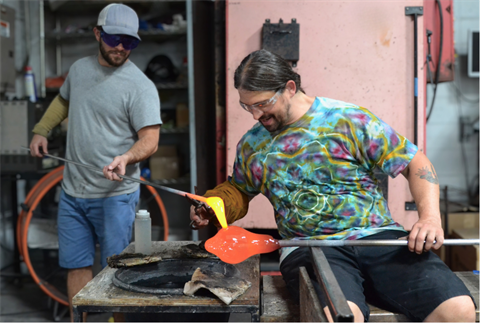 two people blowing glass