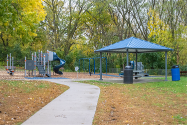 A picnic shelter next to a playground set and swing set