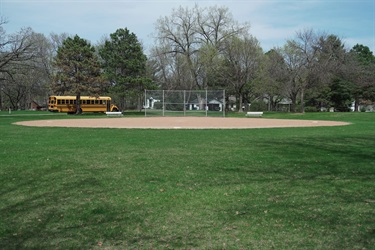 A ballfield in a large grass field