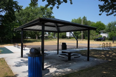 A picnic shelter next to a basketball court