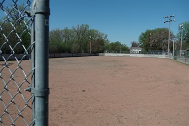 A gravel field that is used as an ice skating rink in the winter