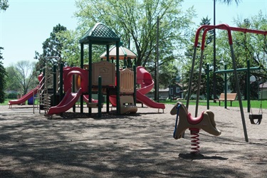A playground with slides, swings and a rocking horse