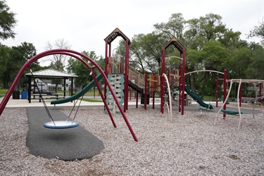 A playground set with a large swing and a climbing wall