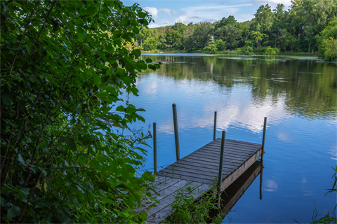 A small fishing pier extends out onto a lake