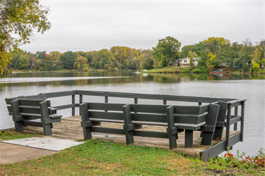 A small fishing pier on the edge of a lake.