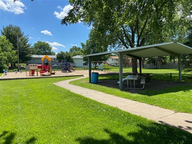 A picnic shelter with several picnic tables underneath