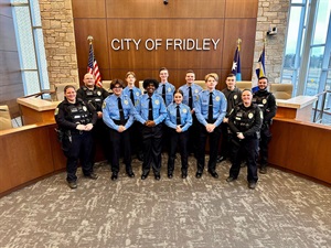 Explorers posing in front of a City of Fridley sign in the Fridley Council Chambers