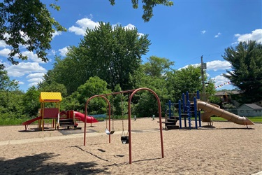 A playground set with swings, slides and stairs