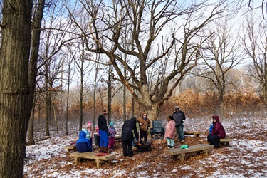 a group of people around a fire in the woods